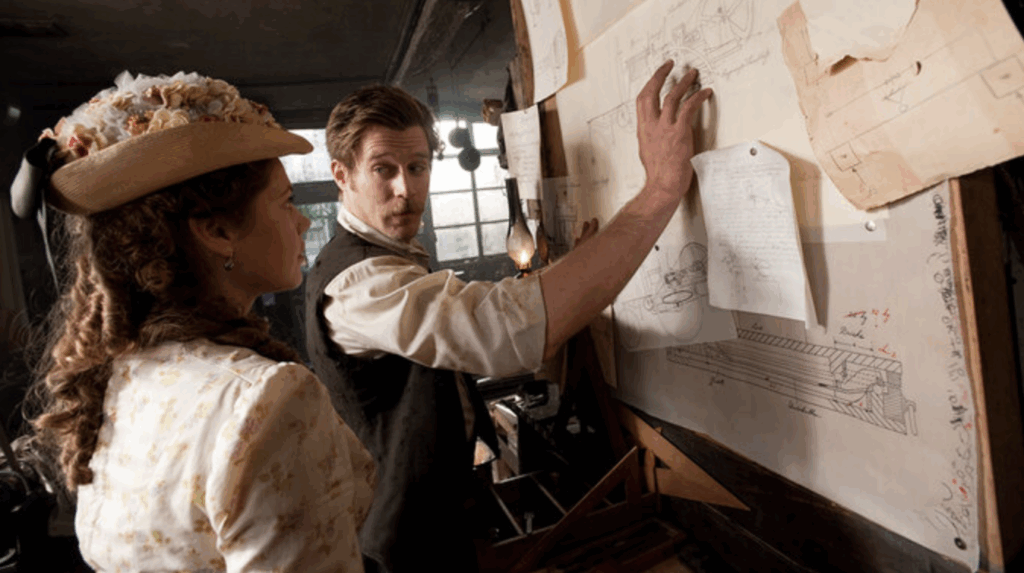 Carl and Bertha making plans in front of a pinboard