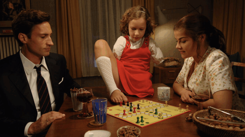 Thalomid Filmposter: A Family is sitting together at a table and is playing ludo