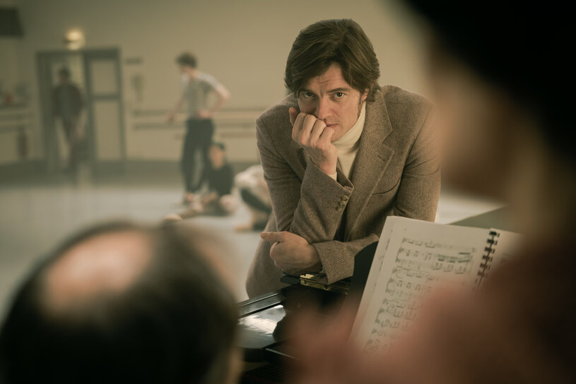 Cranko resting his hand on a table